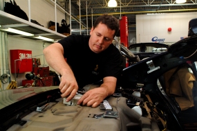 photo of a man working on a car