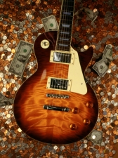 photo of electric guitar on a stack of money